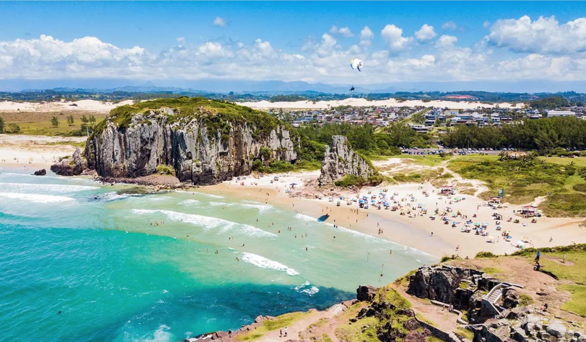Vista aérea da Praia da Guarita, em Torres (RS), com o mar azul e a praia ao fundo